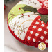Red, green, and white, pincushion made of Christmas themed fabrics, accented with red button and holly leaf appliqué