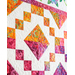 Colorful quilt featuring geometric shapes, diamonds, and swirls in vibrant orange, pink, and white.