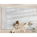 Light blue placemats with floral embroidery in the lower right corner set with dinnerware.