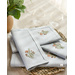 Light blue placemats with floral embroidery in the lower right corner folded and stacked.