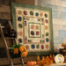 An autumn themed quilt with tossed maple leaf blocks on a wood plank wall