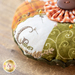 Orange, white, and green fabrics with hand embroidery on the Pumpkin Pie Pin Cushion