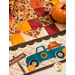 Table runner with square and triangle design with autumn themed fabrics and a truck with pumpkins appliqué on the ends.