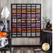 A fun blocked Halloween quilt with white, orange, and purple fabrics hung on a wood textured wall