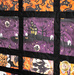 A close up of solid black borders around orange and purple Halloween fabrics