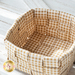 Basket made of woven neutral plaid fabrics.