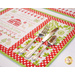 Placemat featuring a Christmas themed cross stitch sample panel print set on a table with silverware.