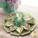 10 sided folded wreath being used as table topper with candle in the middle made of green and purple floral fabrics.