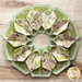 10 sided folded wreath being used as table topper made of green and purple floral fabrics.