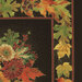 close up image of fabric panel featuring a cornucopia full of pumpkins, apples, and flowers with the word 