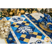 Christmas themed table runner featuring bell designs made of blue and cream snowflake fabrics.