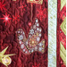 Christmas Joy Quilt Kit featuring a snowflake filled bird ornament on red and gold fabric.