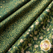 Photo of green fabric with metallic gold accents in mistletoe and star motifs.