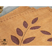 Placemats with stem and leaf cutouts of beige wool felt with hand stitching around the edges.
