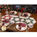 Table runner with 3 hollow star design made of red, black, and green winter theme printed fabric on cream.