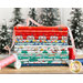 A stack of red, blue, white, and teal illustrated Christmas fabrics next to spools of pink and teal thread