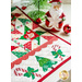 Table runner with triangle pinwheel design in Christmas themed Santa fabrics in red, white, and green.