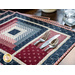 Placemats with log cabin rectangular strip design featuring a pocket for silverware and red, blue, and cream fabric prints.