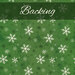 A swatch of green fabric with white and dark green scattered snowflakes.