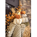 Flannel pumpkins stacked on top of a basket with a knitted blanked.