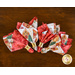Red and white christmas napkins in gold napkin rings arranged in a fan on a brown wooden background