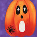 A close up of a fabric panel showing a jack-o-lantern making a scared face with a spider crawling on it