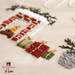 A close up of hand embroidered Christmas presents on fabric