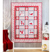 White, red and gray quilt hanging on a gray paneled wall with a small white chair with a red blanket draped over it and a small white shelf with winter decor in the foreground