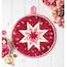 Round folded star hot pad made with red and pink floral fabrics on a white countertop with a bouquet of pink roses nearby and a heart shaped dish full of pink and red buttons