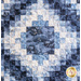 close up of the center of the Irish Chain quilt showing a block of print fabric with a patchwork gradient going outward from it.