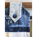 close up image of hanging towel showing printed fabric with a blue cabin scene with pale fabric with snowflakes and a blue button 