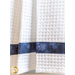 Close up of waffle knit towel with dark blue mottled fabric stripe featuring snowflakes