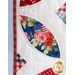 Close up of one quilt block showing fabric detail quilted in the shape of an angular oval with floral patriotic motifs.