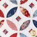 Close up of one quilt block showing fabric detail quilted in the shape of angular ovals with floral patriotic motifs that make up the illusion of a circle with a diamond inside, overlapping other circles..