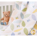 Close up of draped quilt in a white crib with a stuffed bear with blue feet in the background