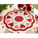 Round white table topper with scalloped edges and red and pink hearts in a circle around it, on a white countertop with red buttons, red thread, red roses, and scissors with a plant in the background