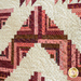 angled image of center of quilt showing quilting texture and swirling patterns