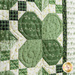 close up of quilting detail on one of the pieced shamrocks with each leaf made with a different shade of green from the Lucky Charms collection on a cream background