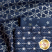 Close up of navy blue fabric with metallic silver winter motifs layered atop one another