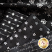 Close up of black fabric with metallic silver winter motifs layered atop one another