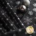 Close up of black fabric with metallic silver winter motifs layered atop one another with two silver ornaments on the furthest right fabric