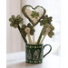 A green mug decorated with white outlines of gnomes with shamrock accents filled with decorative shamrocks and a large stuffed heart on a beaded dowel with embroidery and applique embellishments