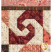 close up of a block featuring a swirl with opposing curved shapes from each corner in cream and burgundy patterned fabrics