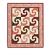 pink, brown and cream mini quilt featuring blocks with a swirling design and a pink border isolated on a white background