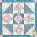close up of one quilt block featuring a classic star pattern made with soft floral pink, blue, and cream fabrics
