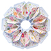 Close up of a flower shaped table topper with central opening. Topper is made of white, soft pink and blue fabrics with multicolor florals isolated on a white background.