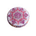 A round purple and pink pincushion quilted in an intricate flower shape isolated on a white background