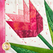 Close up of detail stitching in quilt block featuring a pink tulip with green leaves bordered by pink mottled fabrics