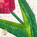 Close up of detail stitching in quilt block featuring a pink tulip with green leaves