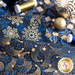 A close up of dark blue and gold metallic fabric fanned out with spools of gold and blue thread and gold ornaments int he background.